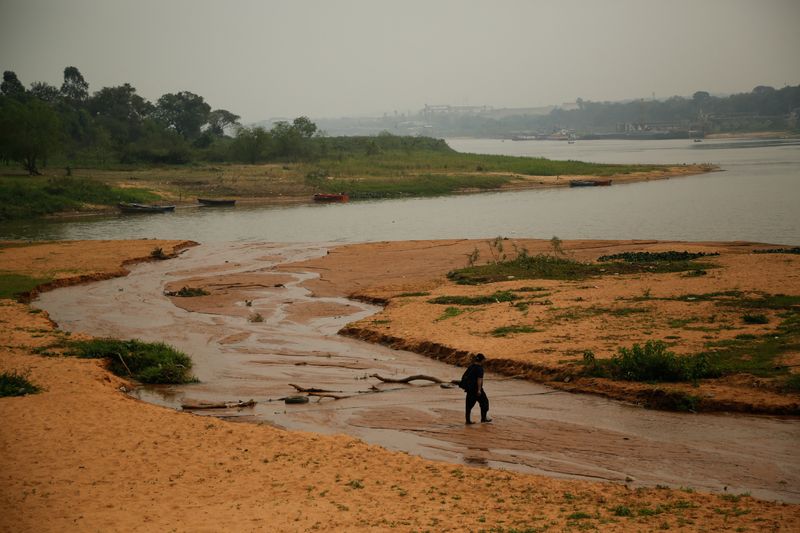 &copy; Reuters. Homem caminha em banco de areia no Rio Paraguai em meio a baixa recorde do rio em San Antonio, no Paraguain07/09/2024 REUTERS/Cesar Olmedo