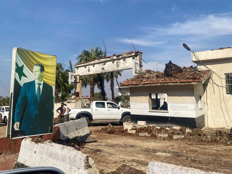 © Reuters. A poster depicting Syria's President Bashar al-Assad is seen at a damaged area in the aftermath of what Syrian state media reported was an Israeli strike in Hama, Syria September 9, 2024. REUTERS/Firas Makdesi