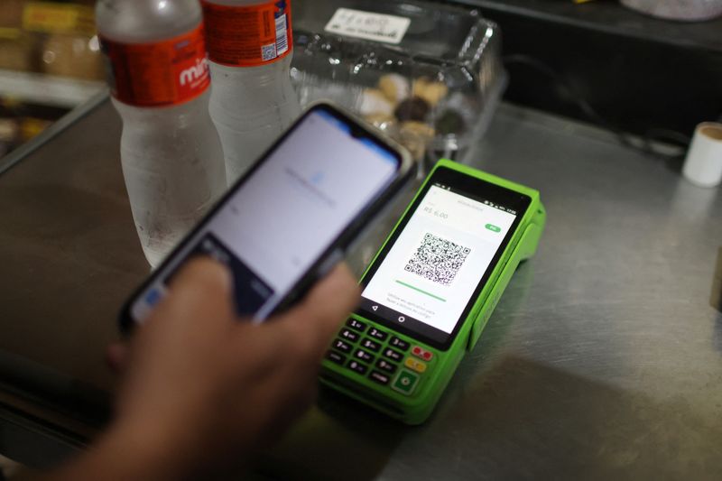 © Reuters. FILE PHOTO: A person pays using their cell phone with the instant electronic payment mode known as PIX, at a store in Rio de Janeiro, Brazil April 1, 2024. REUTERS/Pilar Olivares/File Photo