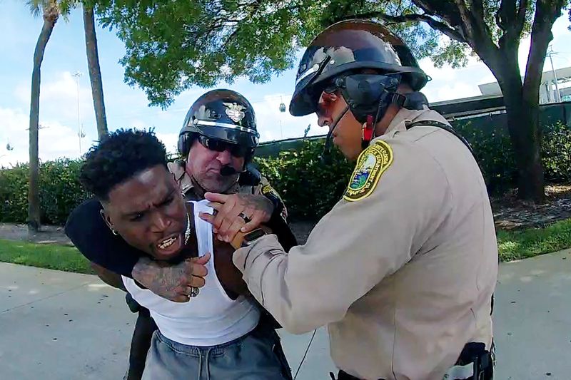 © Reuters. Miami Dolphins receiver Tyreek Hill is forced to the ground after being handcuffed and led to the sidewalk by Miami-Dade Police Department officers in Miami, Florida, September 8, 2024 in a still image from police body camera video.  Miami-Dade Police Department/Handout via REUTERS