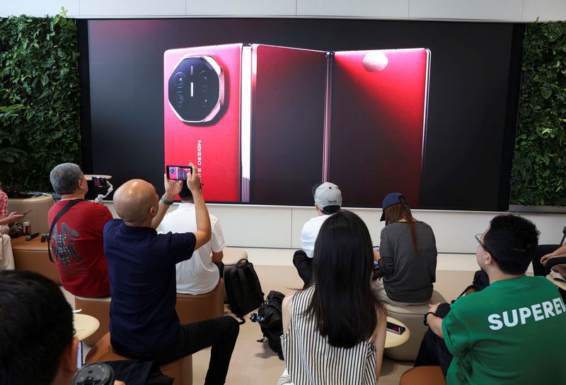 &copy; Reuters. Pessoas assistem vídeo de lançamento de celular Mate XT, da Huawei, em loja da marca em Pequimn10/09/2024 REUTERS/Florence Lo