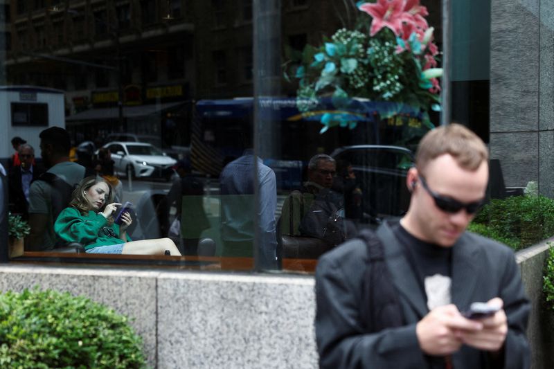 &copy; Reuters. FILE PHOTO: People use mobile phones in New York City, U.S., June 21, 2023. REUTERS/Amr Alfiky/File Photo