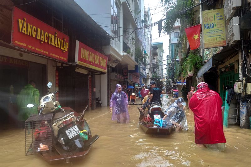 © Reuters. People wade through a flooded street following the impact of Typhoon Yagi, in Hanoi, Vietnam, September 11, 2024. REUTERS/Khanh Vu