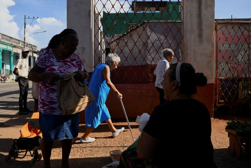 © Reuters. A woman sells spices while others enter a fresh produce market, in Havana, Cuba September 4, 2024. REUTERS/Norlys Perez