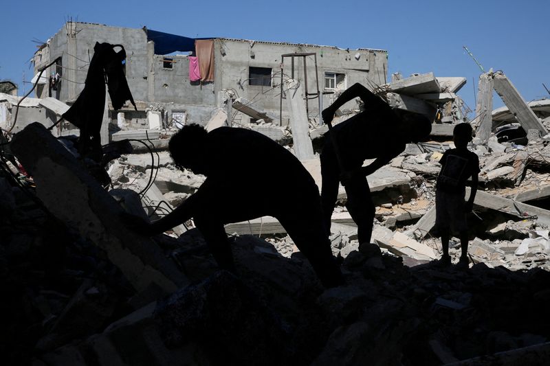 © Reuters. FILE PHOTO: Palestinians remove the rubble of houses destroyed by Israeli strikes, amid Israel-Hamas conflict, in Khan Younis in the southern Gaza Strip, September 4, 2024. REUTERS/Hatem Khaled/File Photo