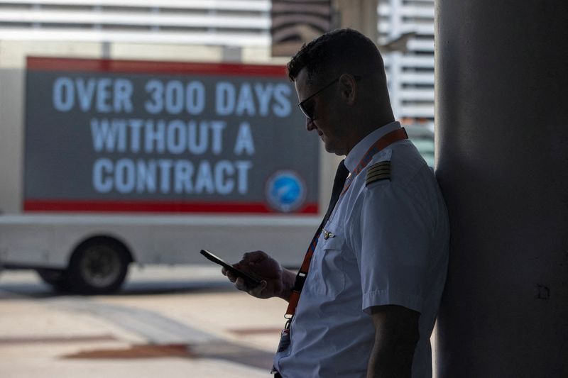 &copy; Reuters. FILE PHOTO: A person holds a mobile phone as Air Canada pilots represented by the Air Line Pilots Association, Int’l (ALPA), who voted to authorize a strike, hold an informational picket at Toronto Pearson International Airport in Mississauga, Ontario, 