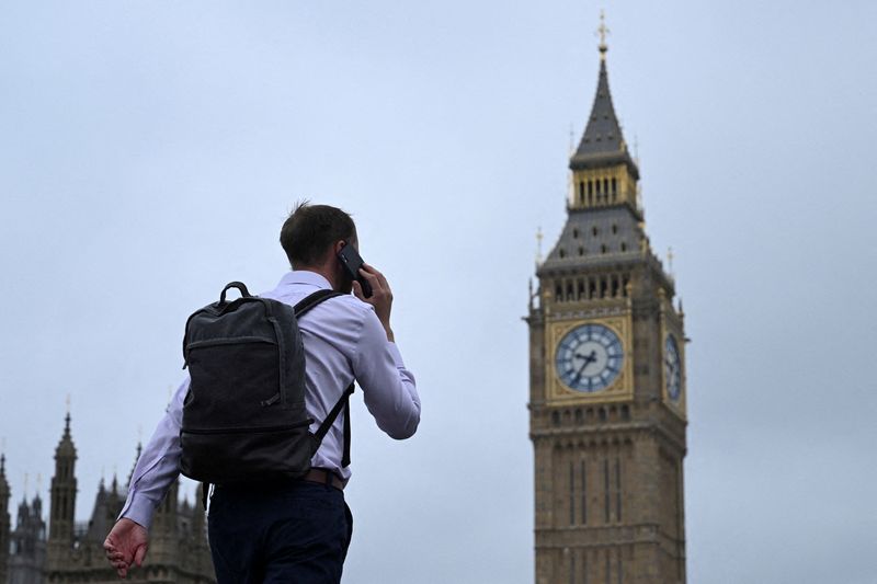 © Reuters. FILE PHOTO: A man walks with his phone on Westminster Bridge towards Big Ben in Westminster, London, Britain, September 2, 2024. REUTERS/Jaimi Joy/File Photo