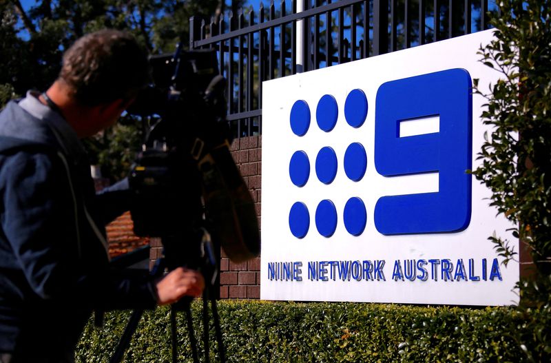 &copy; Reuters. FILE PHOTO: A television cameraman films the logo of Nine Entertainment Co Holdings Ltd on display outside their Sydney headquarters in Australia, July 26, 2018.   REUTERS/David Gray/File Photo