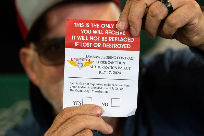 © Reuters. FILE PHOTO: A Boeing worker holds a ballot as Boeing's Washington state factory workers vote on whether to give their union a strike mandate as they seek big salary gains from their first contract in 16 years, at T-Mobile Park in Seattle, Washington, U.S. July 17, 2024.  REUTERS/David Ryder