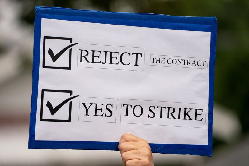 © Reuters. A worker holds a sign as Boeing factory workers wait in line to vote on their first full contract in 16 years, at an International Association of Machinists and Aerospace Workers District 751 union hall, in Renton, Washington, U.S. September 12, 2024.  REUTERS/David Ryder