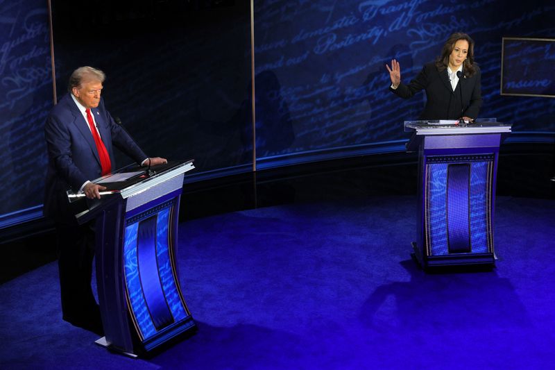 © Reuters. FILE PHOTO: Democratic presidential nominee, U.S. Vice President Kamala Harris speaks during a presidential debate hosted by ABC as Republican presidential nominee, former U.S. President Donald Trump listens, in Philadelphia, Pennsylvania, U.S., September 10, 2024. REUTERS/Brian Snyder/File Photo