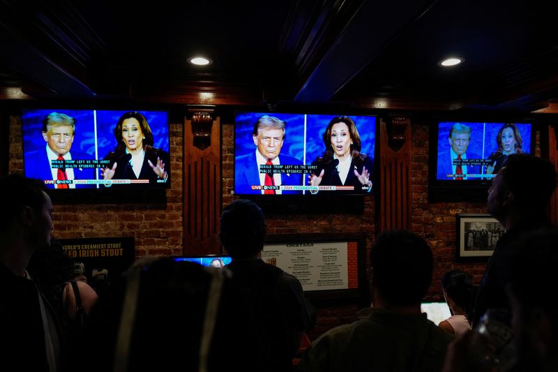 &copy; Reuters. Pessoas em Nova York acompanham debate entre Trump e Kamalan10/09/2024nREUTERS/Adam Gray