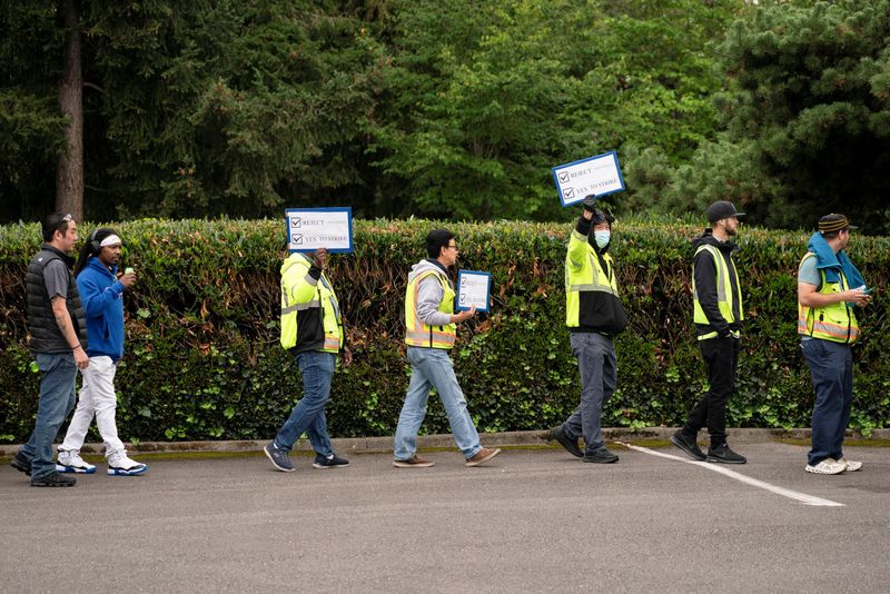 &copy; Reuters. FILE PHOTO: Boeing factory workers hold signs in support of a strike as they wait in line to vote on their first full contract in 16 years, at an International Association of Machinists and Aerospace Workers District 751 union hall, in Renton, Washington,