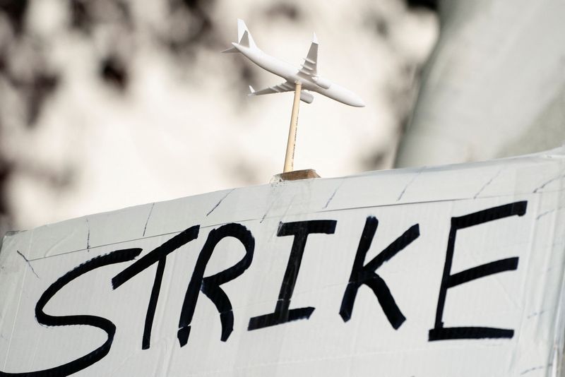 © Reuters. A worker holds a sign in support of a strike as Boeing factory workers wait in line to vote on their first full contract in 16 years, at an International Association of Machinists and Aerospace Workers District 751 union hall, in Renton, Washington, U.S. September 12, 2024.  REUTERS/David Ryder