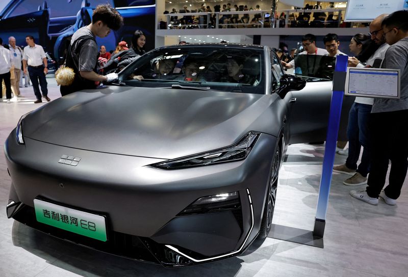 © Reuters. FILE PHOTO: A staff member cleans the Geely Galaxy E8 electric vehicle at the Beijing International Automotive Exhibition, or Auto China 2024, in Beijing, China, April 25, 2024. REUTERS/Tingshu Wang/File Photo