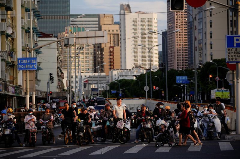 © Reuters. People riding bicycles and motorbikes wait in traffic, amid the coronavirus disease (COVID-19) pandemic, in Shanghai, China May 31, 2021. REUTERS/Aly Song/ File Photo