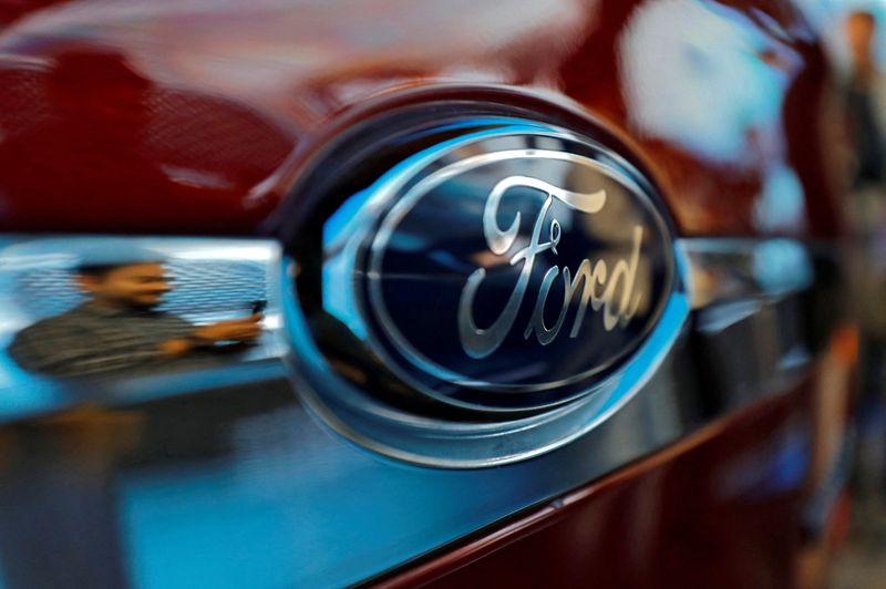 © Reuters. FILE PHOTO: A visitor is reflected as he takes pictures of a new Ford Aspire car during its launch in New Delhi, India, October 4, 2018. REUTERS/Anushree Fadnavis/File Photo