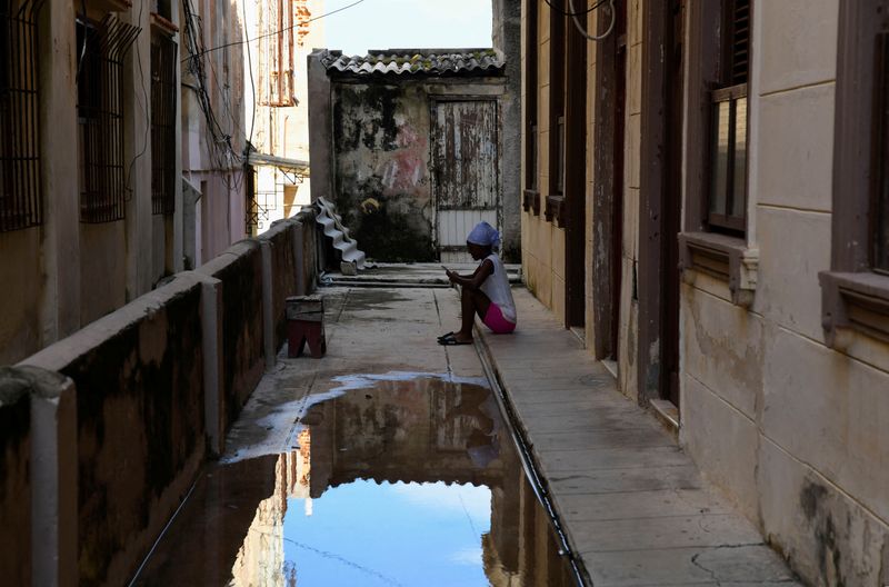 &copy; Reuters. A woman sits outside her home after water was delivered during water shortages, in Havana, Cuba September 11, 2024. REUTERS/Norlys Perez