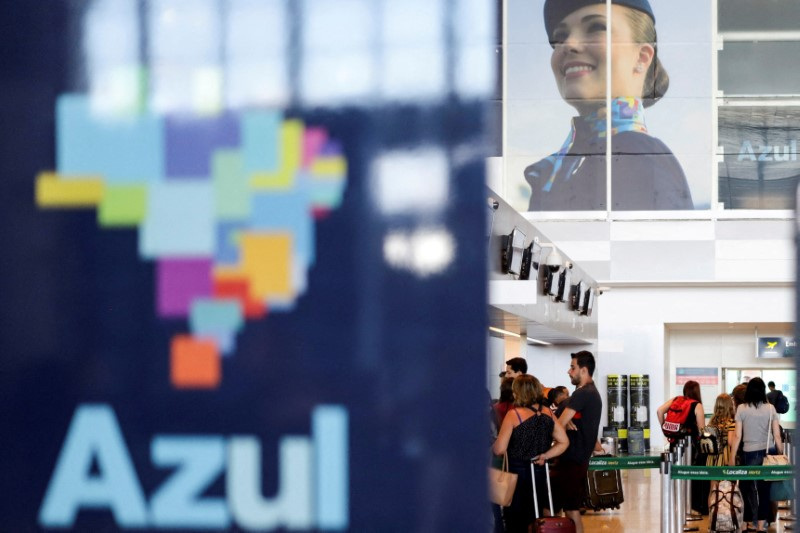 © Reuters. FILE PHOTO: Passengers stand near a sign for Brazilian airline Azul at Viracopos International Airport in Campinas, Sao Paulo state, Brazil March 16, 2020. REUTERS/Rahel Patrasso/File Photo