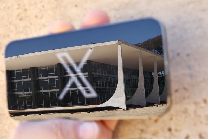 © Reuters. The logo of social media platform X is seen on a mobile phone next to a reflection of the Supreme Court of Brazil, in this illustration taken on Aug. 30, 2024, in Brasilia, Brazil. REUTERS/Ueslei Marcelino/File Photo