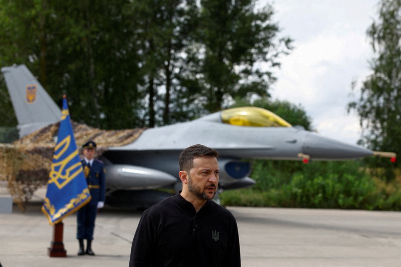 © Reuters. FILE PHOTO: Ukraine's President Volodymyr Zelenskiy speaks to the media in a front of an F-16 fighter jet on the Day of the Ukrainian Air Forces, amid Russia's attack on Ukraine, at an undisclosed location, Ukraine August 4, 2024. REUTERS/Valentyn Ogirenko/File Photo