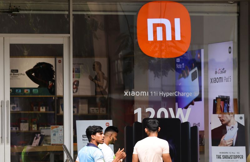 © Reuters. FILE PHOTO: People walk past Xiaomi, a Chinese manufacturer of consumer electronics, store in Mumbai, India, May 11, 2022. REUTERS/Francis Mascarenhas/File Photo