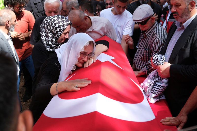 © Reuters. A relative of Aysenur Ezgi Eygi, a Turkish-American activist killed in the Israeli-occupied West Bank, mourns over her Turkish flag-draped coffin during the funeral ceremony at a cemetery in Didim, in the western Aydin province, Turkey, September 14, 2024. REUTERS/Murat Kocabas