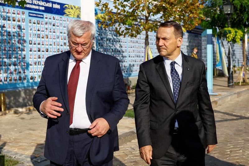 © Reuters. FILE PHOTO: Polish Foreign Minister Radoslaw Sikorski and Ukrainian Foreign Minister Andrii Sybiha visit the Memory Wall of Fallen Defenders of Ukraine outside Saint Michael's Cathedral, amid Russia's attack on Ukraine, in Kyiv, Ukraine September 13, 2024. REUTERS/Valentyn Ogirenko//File Photo