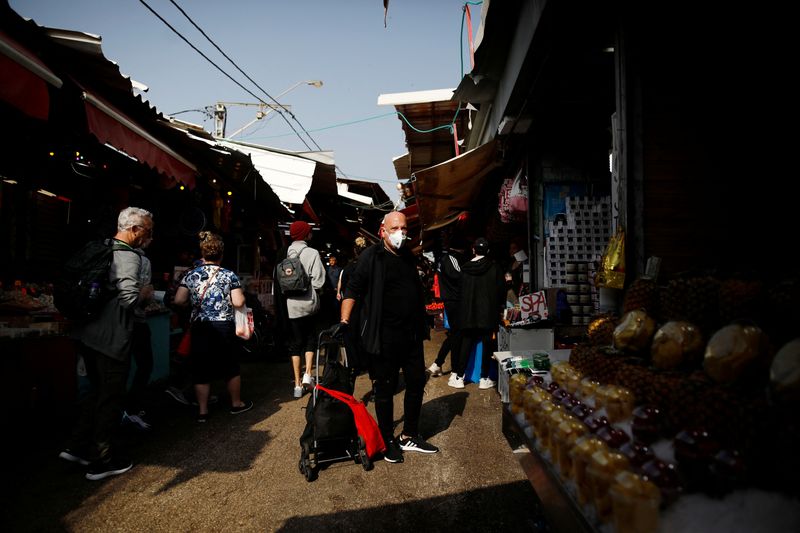 &copy; Reuters. FILE PHOTO: A man wearing a mask shops at a food market in Tel Aviv, Israel March 15, 2020. REUTERS/Corinna Kern/File Photo