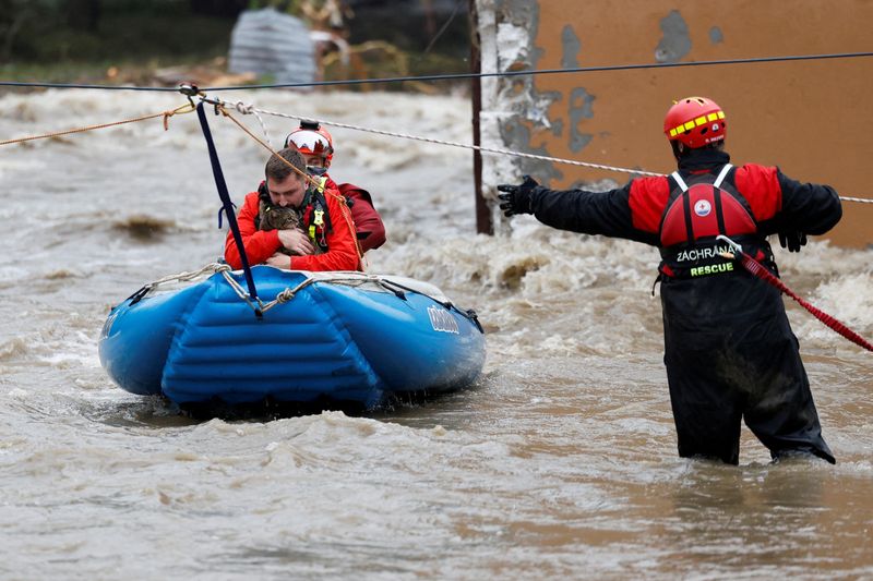 &copy; Reuters. A man holds a cat as he is aided by rescuers on a flooded street, following heavy rainfall in Jesenik, Czech Republic, September 15, 2024. REUTERS/David W Cerny