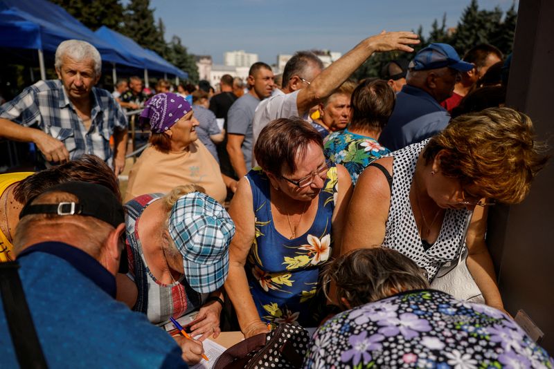 © Reuters. FILE PHOTO: People queue at a humanitarian aid distribution center for residents, who were evacuated from the Kursk region following an incursion of Ukrainian troops in the course of Russia-Ukraine conflict, located in the building of a local circus in Kursk, Russia August 28, 2024.  REUTERS/Maxim Shemetov/File Photo