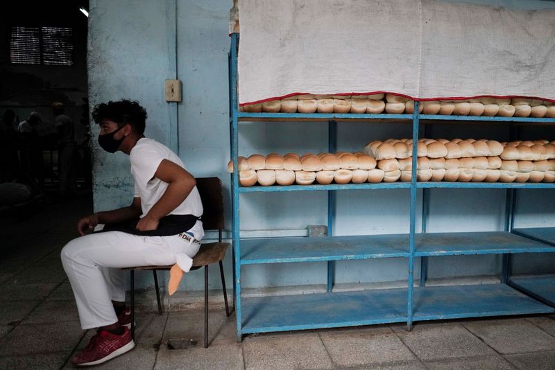 © Reuters. FILE PHOTO: An employee sits beside bread stored on shelves inside a bakery in Havana, Cuba, May 18, 2021. REUTERS/Alexandre Meneghini/File Photo