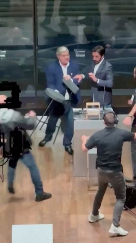 © Reuters. Candidate for Sao Paulo Mayor Jose Luiz Datena throws a chair at his opponent Pablo Marcal (not seen) during a televised debate, in Sao Paulo, Brazil September 15, 2024. SITE TV POP/Reuters TV via REUTERS