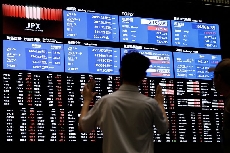 © Reuters. FILE PHOTO: Media members observe the stock quotation board at the Tokyo Stock Exchange in Tokyo, Japan, August 6, 2024. REUTERS/Willy Kurniawan/File photo