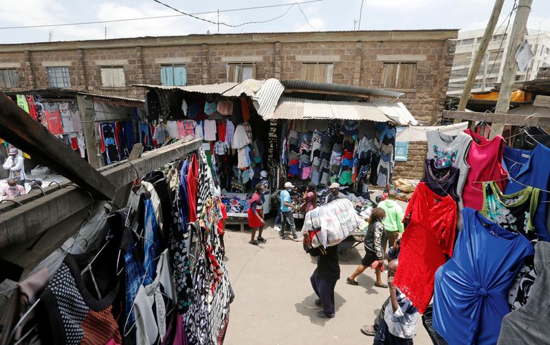 © Reuters. FILE PHOTO: A worker carries a bale of imported second-hand clothes past displayed apparel at the Gikomba market in Nairobi, Kenya, September 18, 2020. REUTERS/Thomas Mukoya