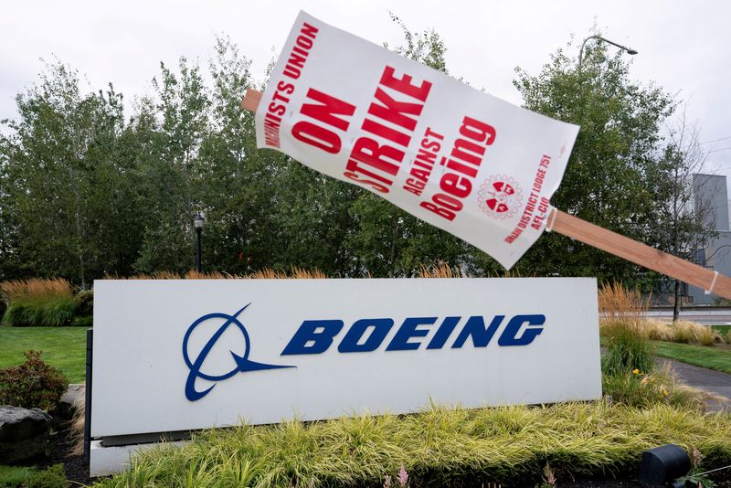 © Reuters. FILE PHOTO: A strike sign hangs from a pole next to a Boeing billboard as Boeing factory workers and supporters gather on a picket line during the third day of a strike outside the entrance to a Boeing manufacturing facility in Renton , Washington, USA, 15 September 2024 . REUTERS/David Ryder/File photo