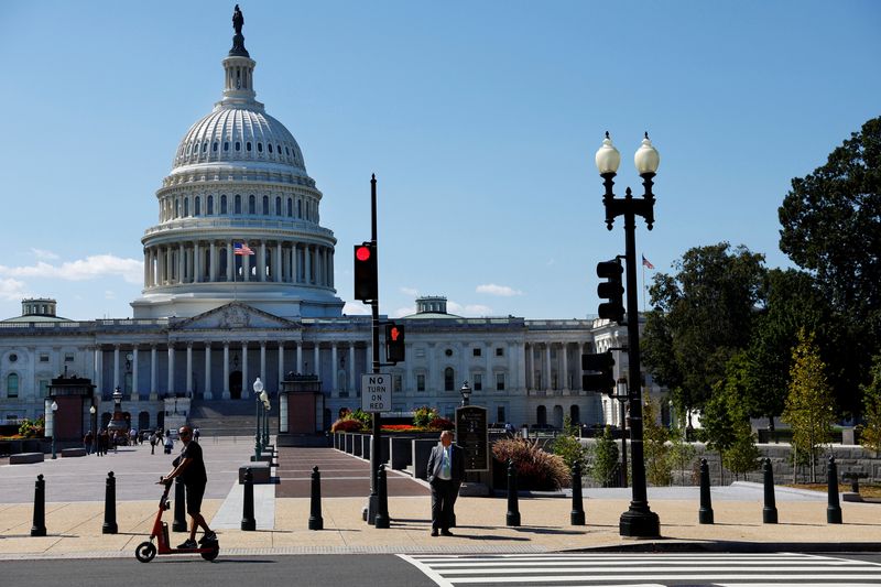 &copy; Reuters. A man passes by the U.S. Capitol on his scooter in Washington, DC, U.S., September 10, 2024. REUTERS/Piroschka van de Wouw/File Photo