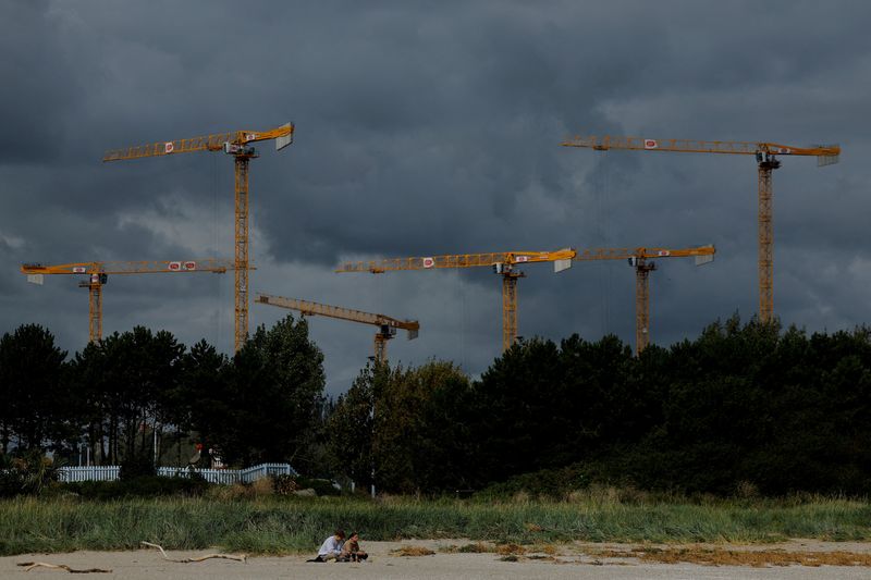 &copy; Reuters. FILE PHOTO: People sit on Sandymount strand beach as construction cranes loom overhead, in Dublin, Ireland August 30, 2023. REUTERS/Clodagh Kilcoyne/File Photo