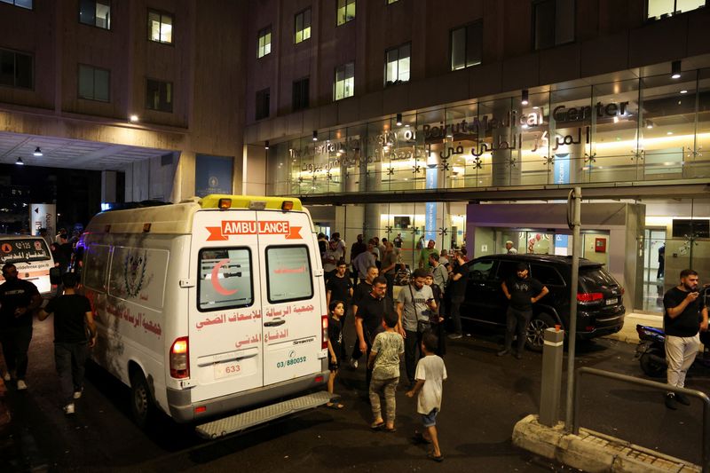 © Reuters. People walk near an ambulance outside American University of Beirut Medical Center (AUBMC) as people, including Hezbollah fighters and medics, were wounded and killed when the pagers they use to communicate exploded across Lebanon, according to a security source, in Beirut, Lebanon September 17, 2024. REUTERS/Mohamed Azakir