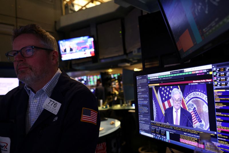 © Reuters. FILE PHOTO: A trader works on the floor of the New York Stock Exchange (NYSE) as a screen shows Federal Reserve Chairman Jerome Powell during a news conference after the Fed's rate announcement in New York City , USA, February 1, 2023. REUTERS/Andrew Kelly/File photo