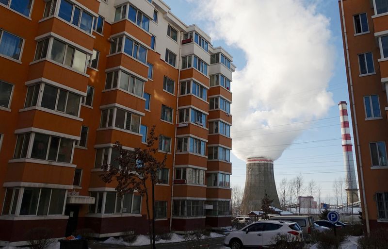 &copy; Reuters. FILE PHOTO: Smoke billows from a cooling tower of a thermal power plant near residential buildings in the coal city of Hegang, Heilongjiang province, northeast China January 2, 2020. REUTERS/Ryan Woo/File Photo