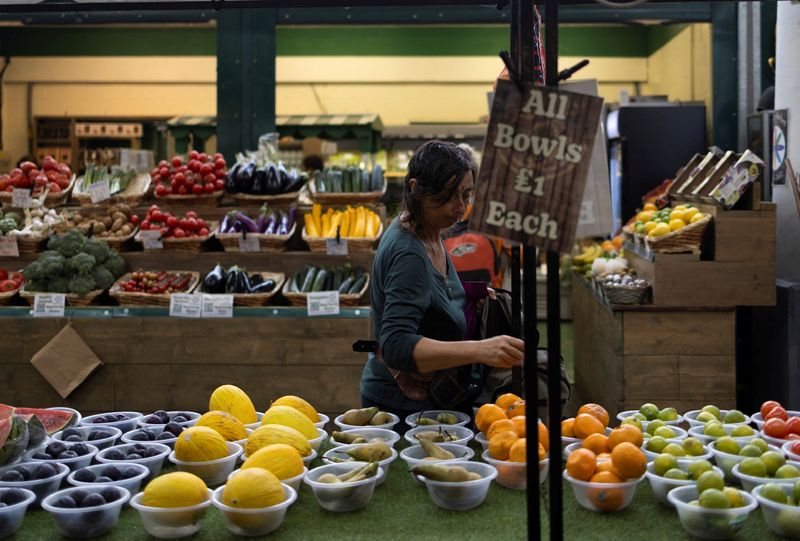 &copy; Reuters. FILE PHOTO: A woman buys fruits and vegetables at the local market in Brighton, Britain, June 28, 2024. REUTERS/Carlos Jasso/File photo