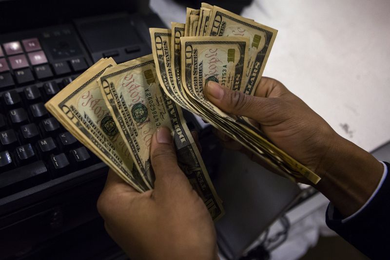 © Reuters. FILE PHOTO: A cashier counts out money in New York November 28, 2013.  REUTERS/Eric Thayer/file photo