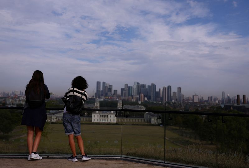 &copy; Reuters. FILE PHOTO: People look out to Canary Wharf financial district from Greenwich Park in London, Britain, August 28, 2024. REUTERS/Hannah McKay/File Photo