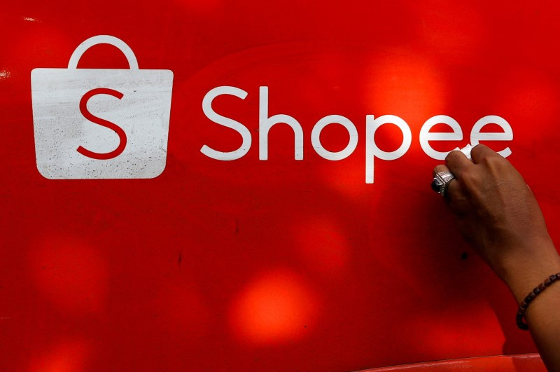 &copy; Reuters. FILE PHOTO: A worker wipes the door of a car with the sign of Shopee, an Indonesian e-commerce platform, in Jakarta, Indonesia, February 5, 2021. REUTERS/Ajeng Dinar Ulfiana/File Photo