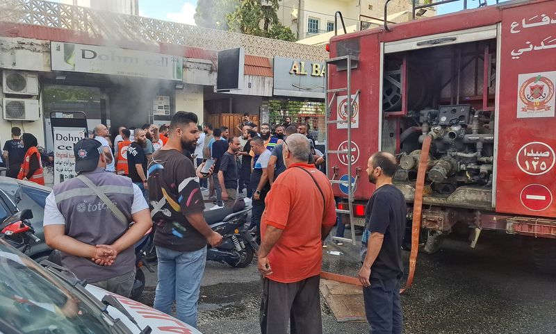 &copy; Reuters. People gather as smoke rises from a mobile shop in Sidon, Lebanon September 18, 2024. REUTERS/Hassan Hankir