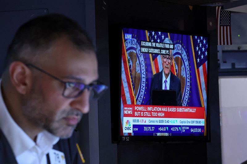 © Reuters. FILE PHOTO: A trader works, as a screen broadcasts a news conference by U.S. Federal Reserve Chair Jerome Powell following the Fed rate announcement, on the floor of the New York Stock Exchange (NYSE) in New York City, U.S., March 20, 2024.  REUTERS/Brendan McDermid/File Photo