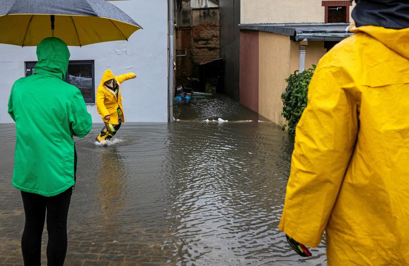 &copy; Reuters. FILE PHOTO: People stand on a flooded street following heavy rainfalls in Glucholazy, Poland, September 14, 2024. Grzegorz Celejewski / Agencja Wyborcza.pl via REUTERS/File Photo