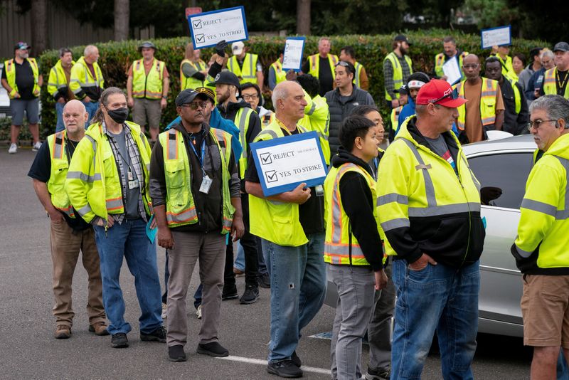 © Reuters. Boeing factory workers hold signs as they wait in line to vote on their first full contract in 16 years, at an International Association of Machinists and Aerospace Workers District 751 union hall, in Renton, Washington, U.S. September 12, 2024.  REUTERS/David Ryder/File Photo