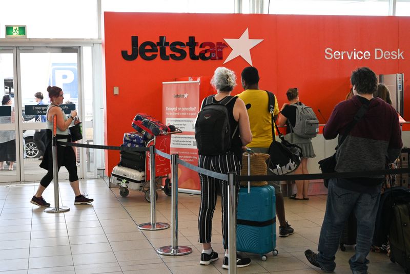 &copy; Reuters. FILE PHOTO: Travelers wait in line at a Jetstar Airways counter at Kingsford Smith International Airport, in Sydney, Australia, March 18, 2020. REUTERS/Loren Elliott/ File Photo